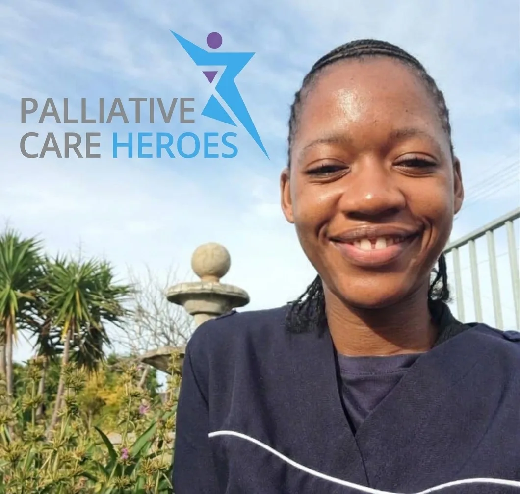 Ashley smiling outdoors in her carer’s uniform, with the Palliative Care Heroes logo